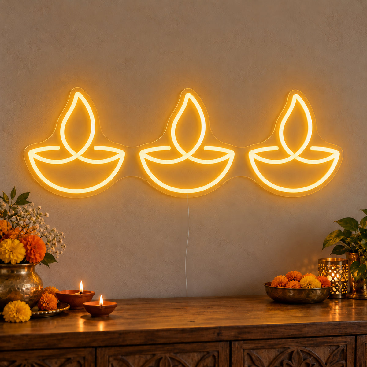 Three Diyas Neon Sign on clear cut-to-shape acrylic, illuminated on a wall in a styled celebration setting