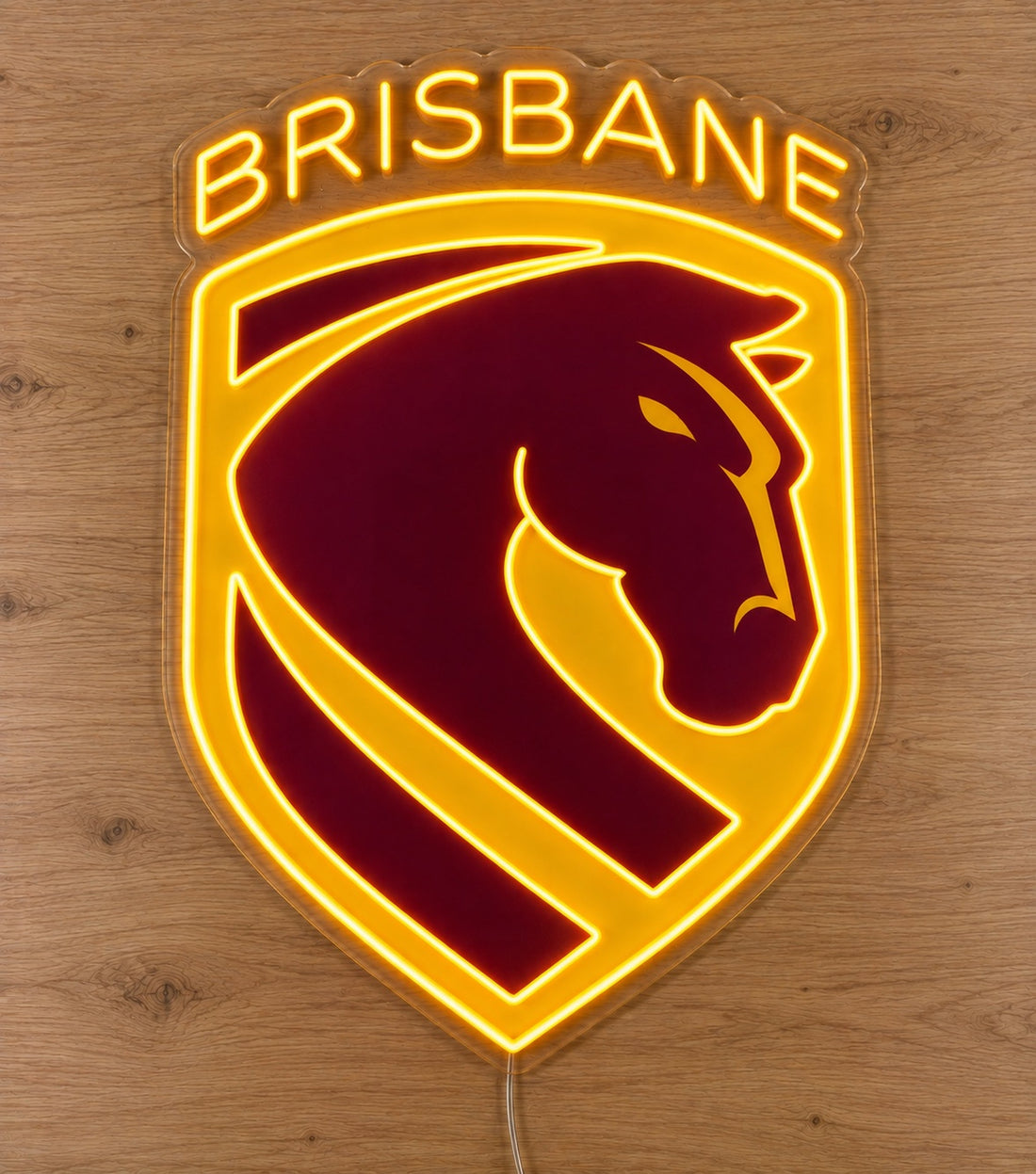 Brisbane Broncos Neon Sign, featuring illuminated team logo on a wooden surface.