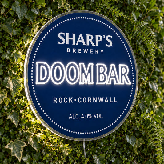 Doom Bar LED Neon Sign, featuring beer-brand logo displayed on a green foliage wall.