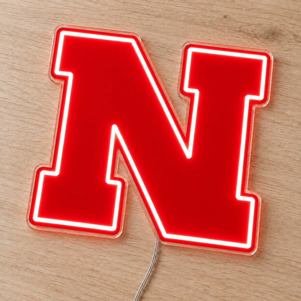 Nebraska Cornhuskers LED Neon Sign, featuring team logo displayed on a wooden surface.