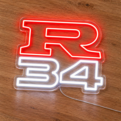 Nissan R34 LED Neon Sign in red and white, featuring R34 lettering on a wooden surface.
