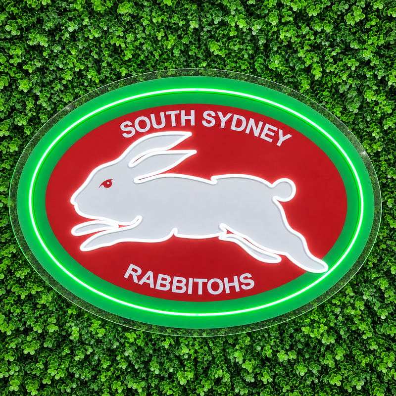 South Sydney Rabbitohs Neon Sign, featuring illuminated team logo on a green foliage wall.