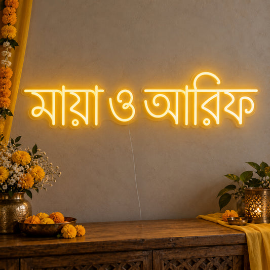 Personalised Bengali Couple Names Neon Sign on clear cut-to-shape acrylic in an illuminated wall display; example personalisation shown.