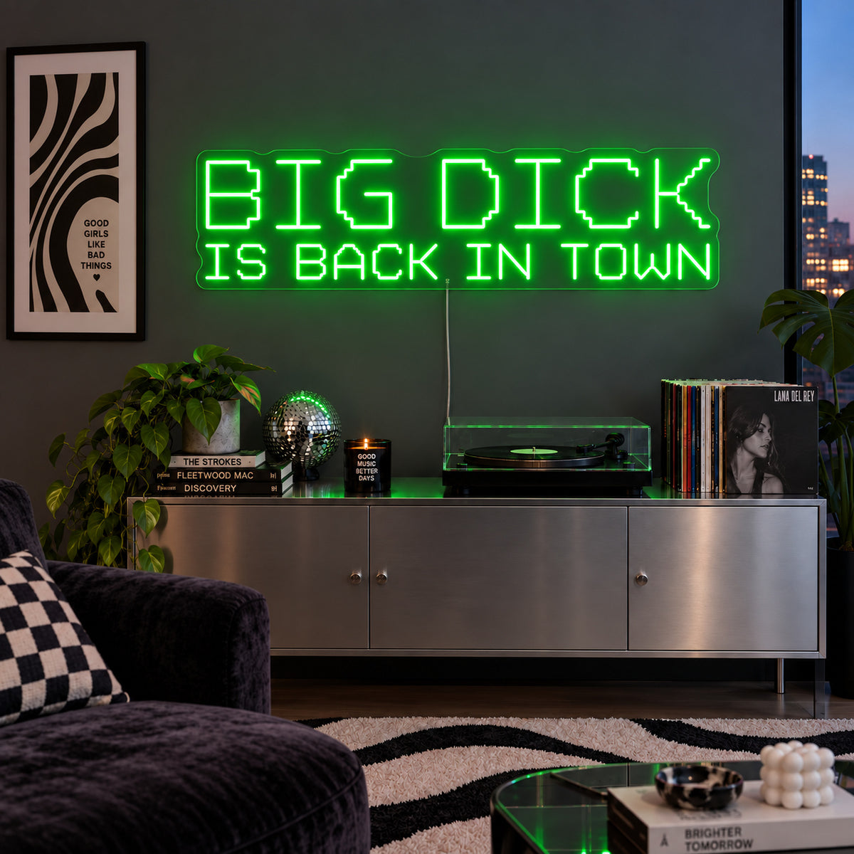 Big Dick Is Back In Town Neon Sign with green lighting, displayed above a record player and metal sideboard.