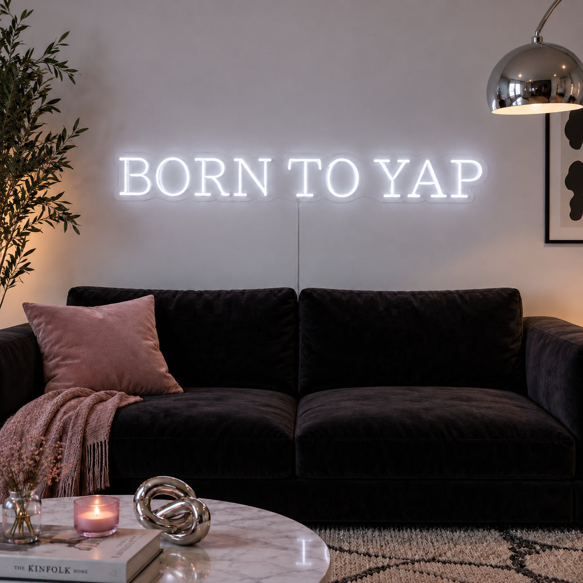 Born To Yap Neon Sign, RGB colour-changing option shown in white above a dark sofa and glass coffee table.