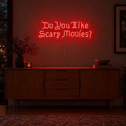Do You Like Scary Movies Neon Sign featuring the question Do You Like Scary Movies in decorative red lettering, displayed on a dark wall above a wooden sideboard.