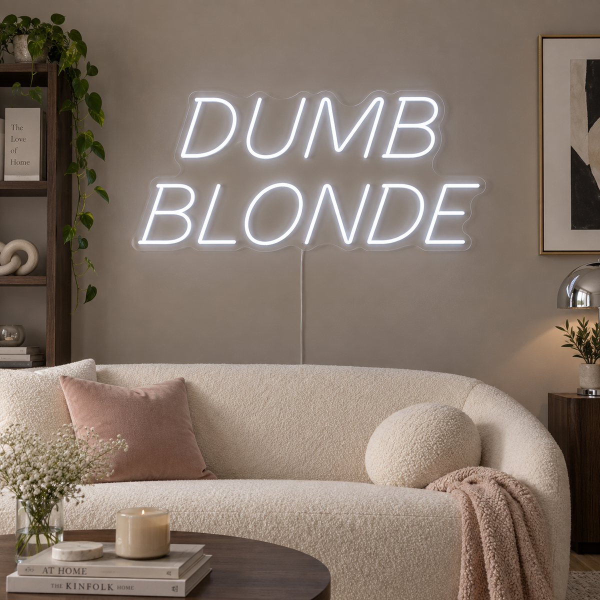Dumb Blonde Neon Sign, RGB colour-changing option shown in white in slanted lettering above a cream sofa.
