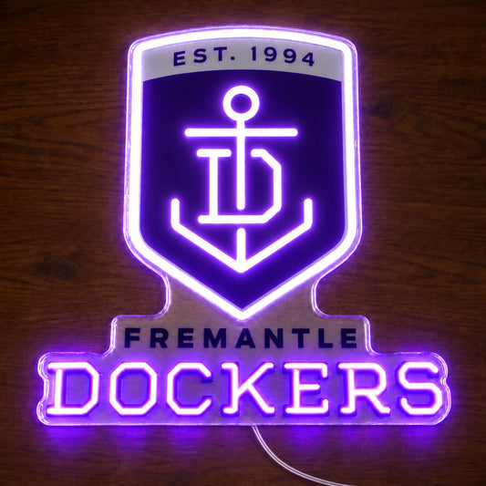 Fremantle Dockers neon sign glowing brightly on a wooden surface in dim lighting