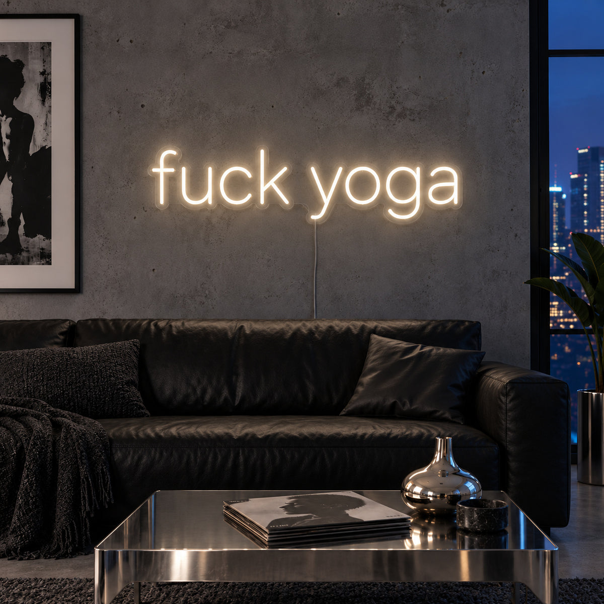 Warm White version of the Fuck Yoga Neon Sign, shown above a black leather sofa.