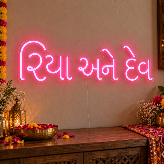 Personalised Gujarati Couple Names Neon Sign on clear cut-to-shape acrylic in an illuminated wall display; example personalisation shown.