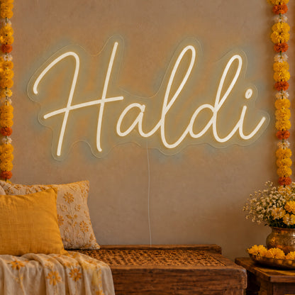Haldi Neon Sign in warm white LED neon on clear acrylic, angled view