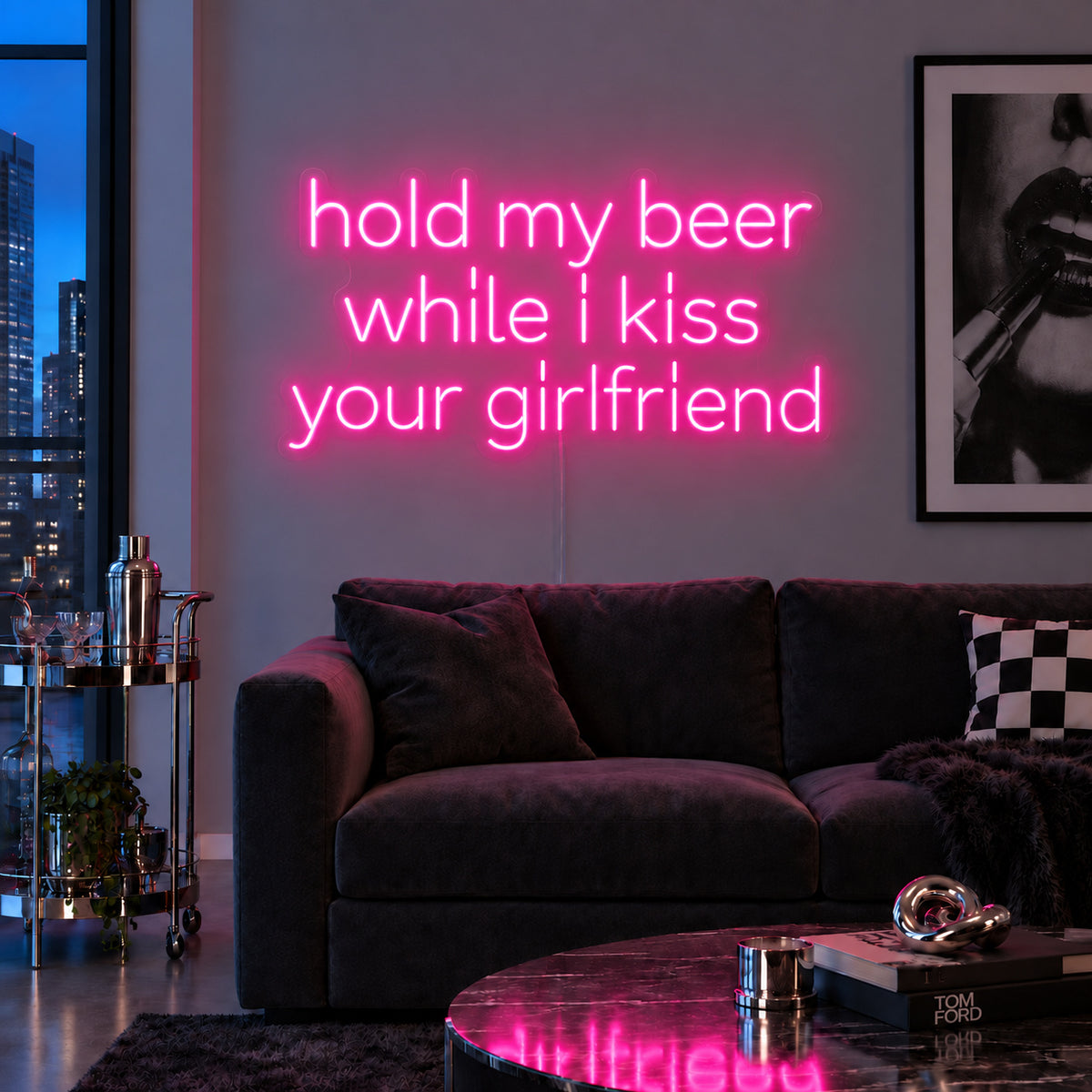Hold My Beer While I Kiss Your Girlfriend Neon Sign glowing pink above a burgundy sofa.