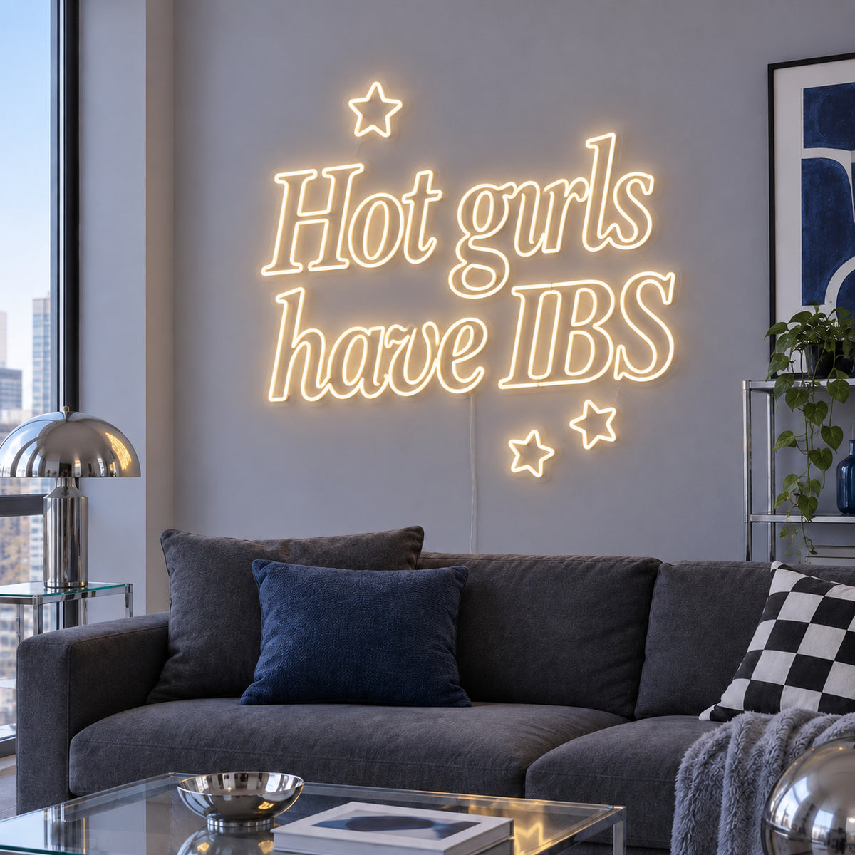 Warm White version of the Hot Girls Have IBS Neon Sign, shown with star details above a charcoal sofa.