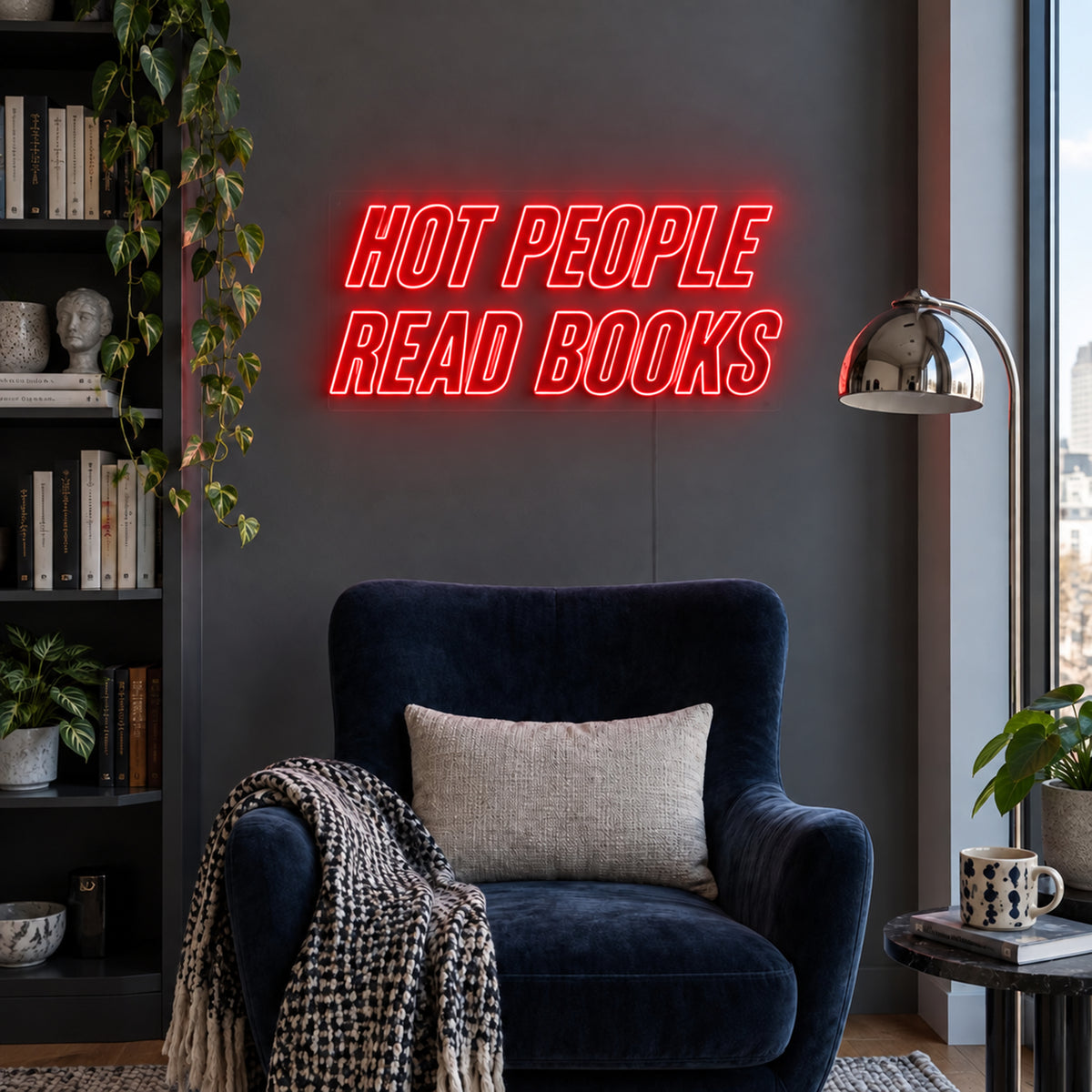 Hot People Read Books Neon Sign in red above a blue reading chair.
