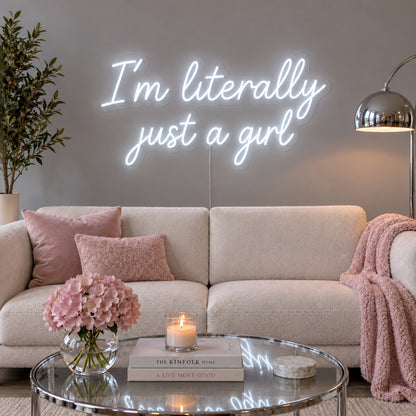 I'm Literally Just A Girl Neon Sign glowing white above a cream sofa.