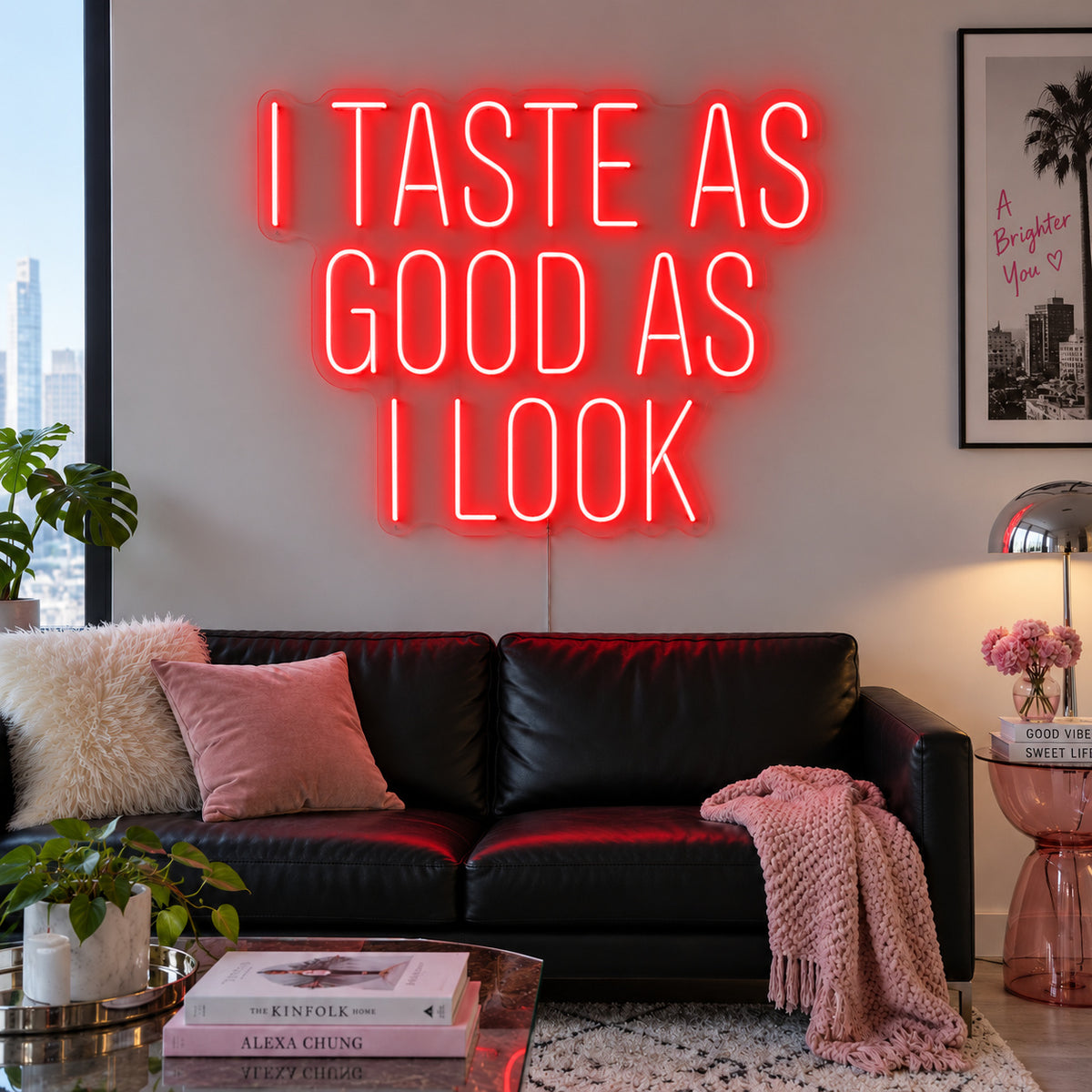 I Taste As Good As I Look Neon Sign with red lighting, displayed above a black sofa.