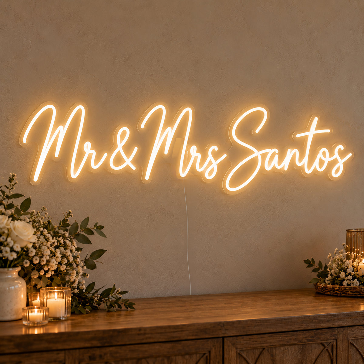 Personalised Mr & Mrs Surname Neon Sign on clear cut-to-shape acrylic, illuminated on a wall in a styled celebration setting; sample personalised wording shown