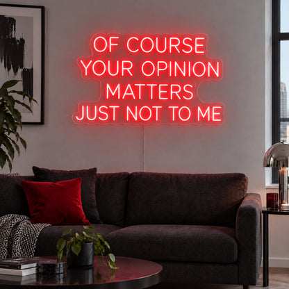 Of Course Your Opinion Matters Just Not To Me Neon Sign with red lighting, displayed above a black sofa.