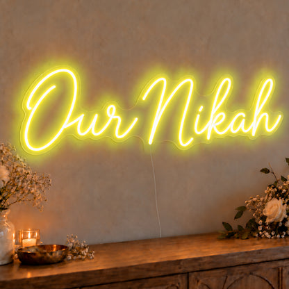 Our Nikah Neon Sign in yellow LED neon on clear acrylic, angled view