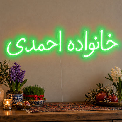Personalised Farsi Family Name Neon Sign in green LED neon on clear acrylic, angled view