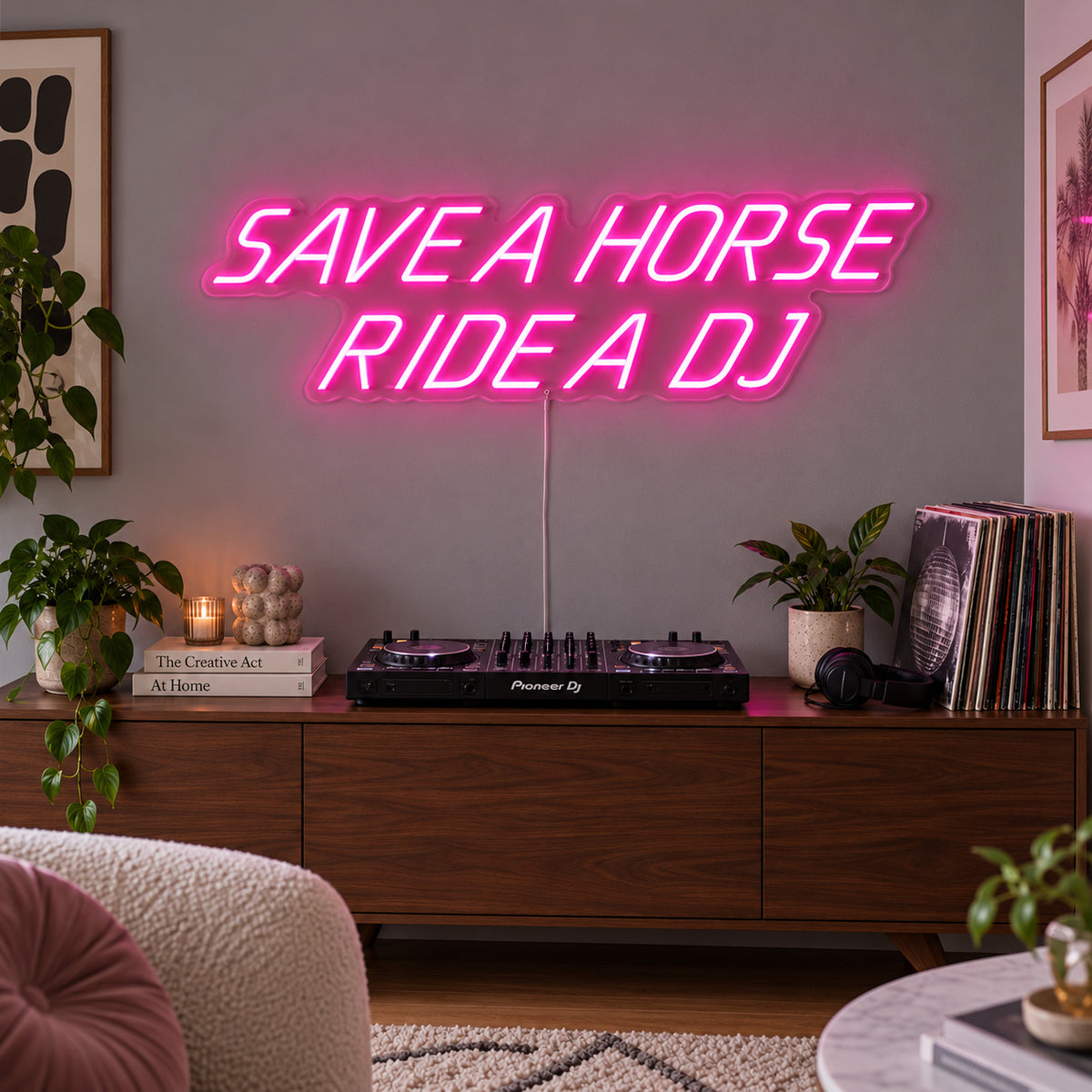 Rose Red version of the Save A Horse Ride A DJ Neon Sign, shown above a turntable on a wooden sideboard.