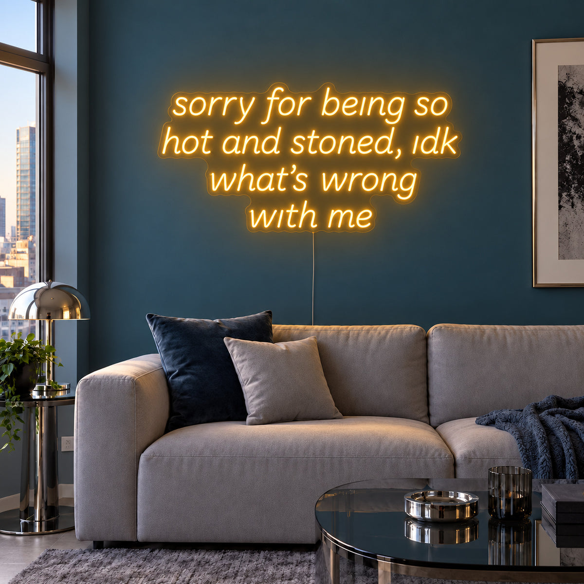 Sorry For Being So Hot And Stoned, Idk What's Wrong With Me Neon Sign glowing gold above a grey sofa against a blue wall.
