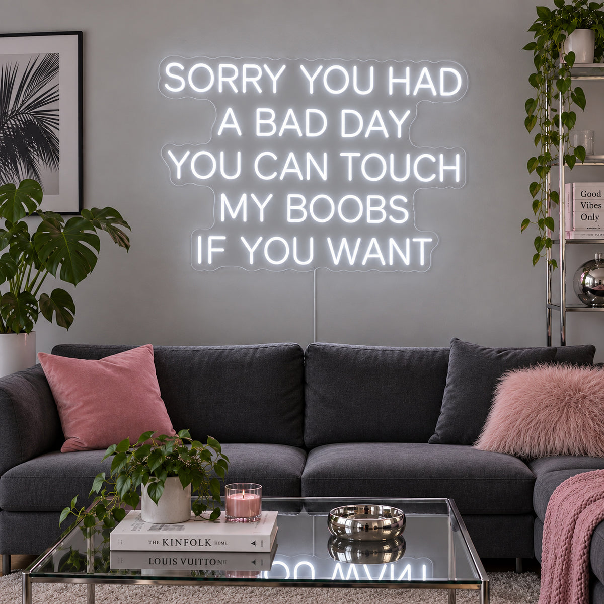 Sorry You Had A Bad Day You Can Touch My Boobs If You Want Neon Sign, RGB colour-changing option shown in white above a grey sofa with pink cushions.